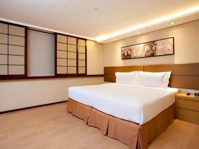 a bedroom with a large white bed and windows at Jinjiang Inn - Makati in Manila