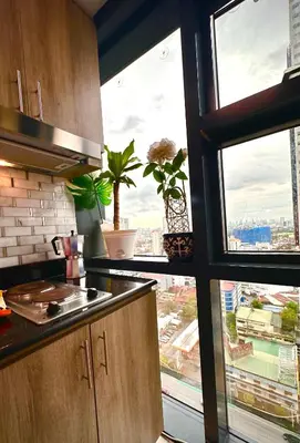 a kitchen with a view of a city from a window at City Escape by Fame in Manila