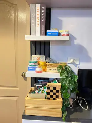 a book shelf filled with books and a wooden box at Your Comfort Zone Staycation2 in Manila