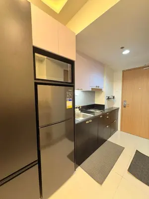 a kitchen with a stainless steel refrigerator and cabinets at A&P Residence in Manila