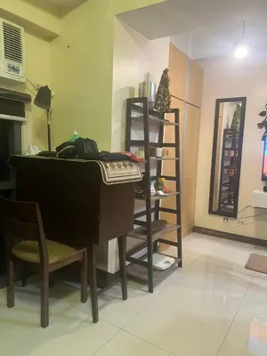 a living room with a piano and a book shelf at McKinley viceroy Haven with free indoor parking in Manila