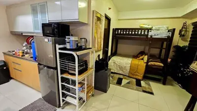 a kitchen with a refrigerator and a bunk bed at McKinley viceroy Haven with free indoor parking in Manila