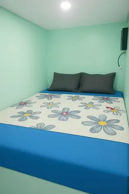 a bedroom with a bed with a blue light at Uni Capsules in Manila