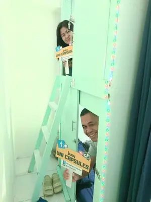 a man holding a box in front of a mirror at Uni Capsules in Manila