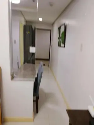 a hallway with a chair and a mirror in a room at Birch tower condo for renting in Manila