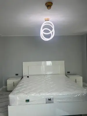 a white bed in a room with a light at Robinson's place residences tower 2 in Manila