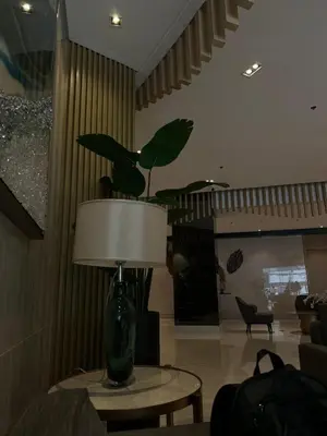 a living room with a vase on a table with a lamp at Luxe Hotel-Style Suite Stay at Ayala Ave in Manila