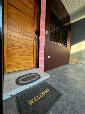 a welcome mat in front of a wooden door at Casa Deña Lawa - Cozy Staycation in Calamba in Calamba