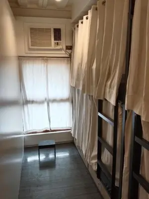 a small room with a window and a fan at Quarto Ph in Manila