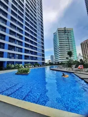 a large swimming pool in front of some tall buildings at Skyline Serenity at 52F & Cozy City Escape Views in Manila