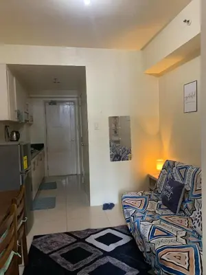 a living room with a couch and a kitchen at Sea Residences DINA in Manila