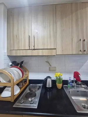 a kitchen with wooden cabinets and a stove and a sink at Wowstaycation in Manila