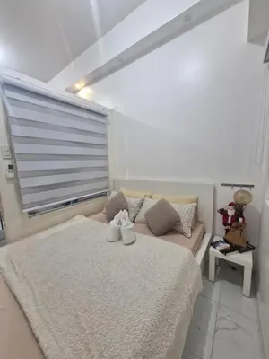 a bedroom with a large bed and a window at Wowstaycation in Manila