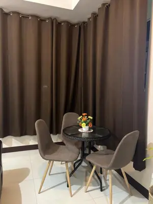 a table with two chairs and a vase of flowers on it at Newport Inn in Manila