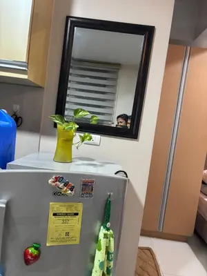 a mirror on top of a refrigerator in a kitchen at Newport Inn in Manila