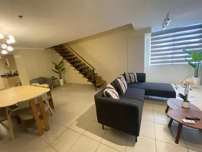 a living room with a couch and a table at EDSA Heights Unit 3422 Two br Penthouse Loft Unit AMA Tower residences in Manila