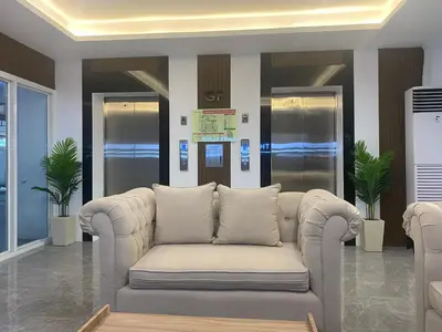 a living room with a couch in a lobby at The Courtyard Contemporary Studio at Taguig WiFi in Manila