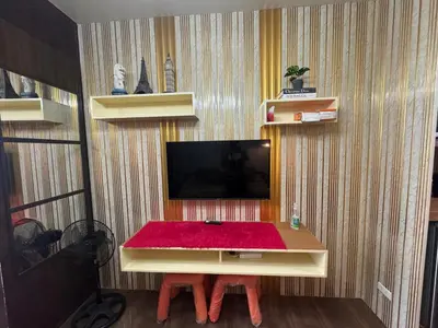 a room with a table with a tv on a wall at Air Residences MKT in Manila