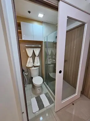 a bathroom with a toilet and a glass shower at Elegant MOA Condo at Shore Residence near the Bay in Manila