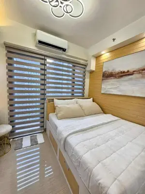 a large bed in a room with a large window at Elegant MOA Condo at Shore Residence near the Bay in Manila