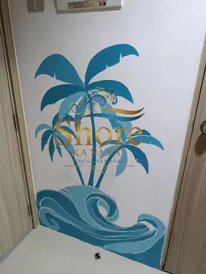 a bathroom door with a palm tree on the wall at Amenity Area 2nd floor in Manila