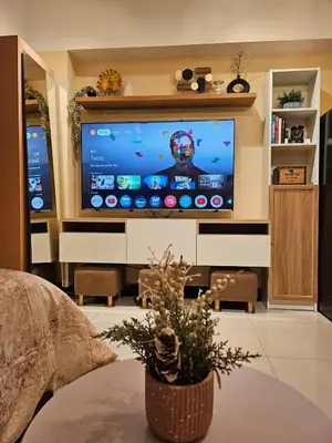 a living room with a large flat screen tv at Elivion Staycations in McKinley Hill BGC with Pool near Venice Mall in Manila