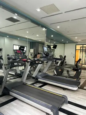 a gym with several tread machines in a room at Elivion Staycations in McKinley Hill BGC with Pool near Venice Mall in Manila