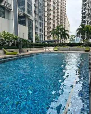 a large swimming pool in a city with tall buildings at Elivion Staycations in McKinley Hill BGC with Pool near Venice Mall in Manila