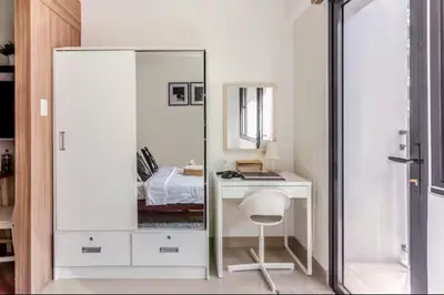 a bedroom with a mirror and a desk with a chair at MOA Condotel 1BR fast WiFi in Manila