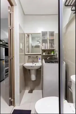 a white bathroom with a sink and a toilet at MOA Condotel 1BR fast WiFi in Manila