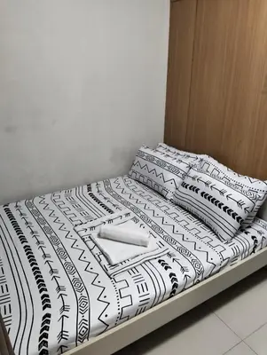 a bed with black and white sheets and pillows at Shell Residences Mall of Asia by Jade in Manila