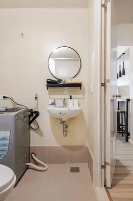 a bathroom with a sink and a mirror on the wall at Studio Lune - Heart of Makati in Manila