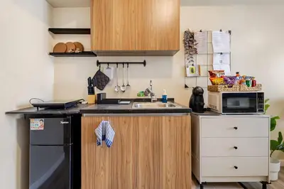 a small kitchen with a sink and a microwave at Studio Lune - Heart of Makati in Manila
