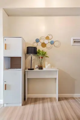 a white table with a vase on it in a room at Studio Lune - Heart of Makati in Manila