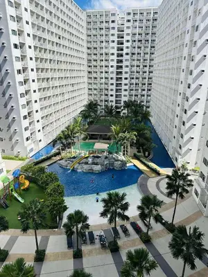 an aerial view of a large pool with palm trees and buildings at Shore Residences in Manila