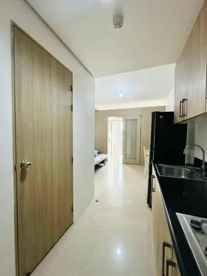 a kitchen with a door leading to a living room at Shore Residences in Manila