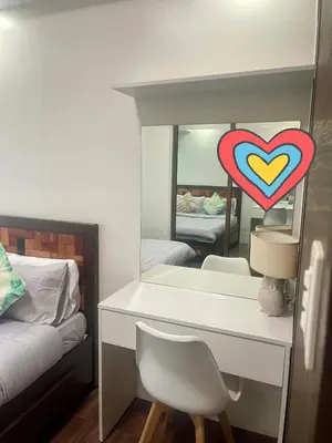a bedroom with a desk with a heart on a mirror at Maison de Joie' in Manila