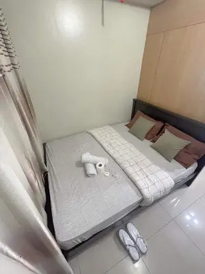 a small room with a bed with two towels on it at Pasay Moa Stay at Shell Residences in Manila