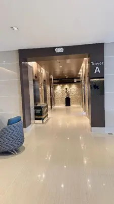 a lobby of a hotel with a couch and a sign at The Luxe Nook Shore Residences MOA in Manila