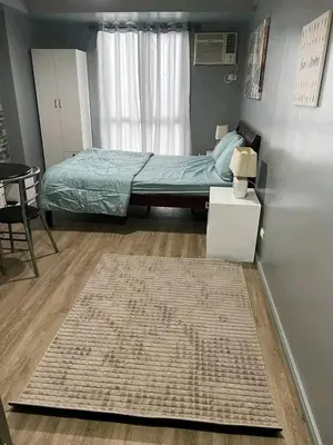 a small bedroom with a bed and a rug at Vacation in Tribecca Towers in Manila