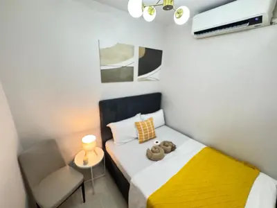 a small bedroom with a bed and a chair at S Residences Family Room 512 by Prime Stay MOA in Manila