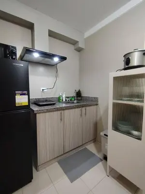 a kitchen with a black refrigerator and a sink at Coco Home in Manila