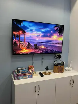 a flat screen tv hanging on a wall at Azure Urban Resort by Cozy Haven in Manila