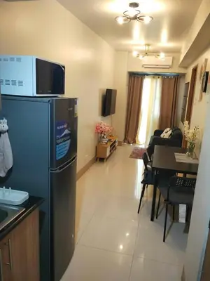 a kitchen and living room with a refrigerator and a table at Pasay FL Staycation in Manila
