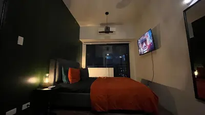 a bedroom with a bed and a tv on the wall at Air Residences Minimal Style Unit w Balcony - Near Trident Tower and Salcedo in Manila