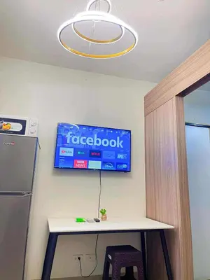 a sign on a wall above a table and a refrigerator at SHORE 2 TOWER 3 Near MOA Easy Vacation Shopping Center in Manila