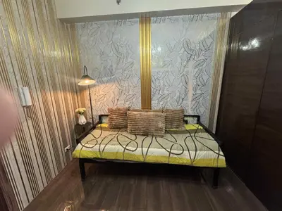 a bedroom with a bed with pillows on it at Air Residences 2111k'Pads in Manila