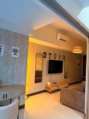 a living room with a couch and a tv at Cozy Modern- King Bed- City View in Manila