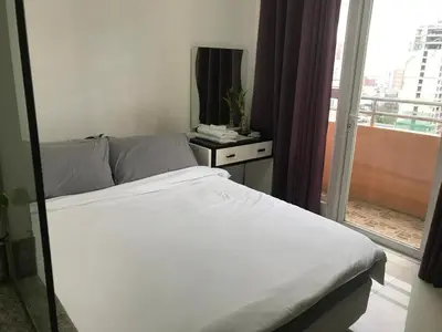 a bed in a room with a view of a balcony at Birch Tower Manila by JL in Manila