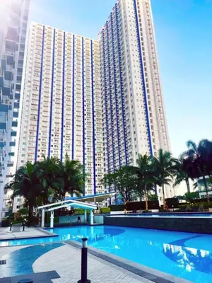 a large building with a large swimming pool in front of it at Transient Home Serenity in Manila